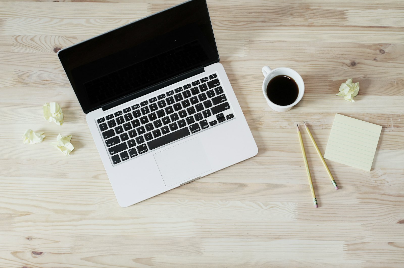 Opgeruimd bureau met laptop, koffie en een notitieblok voor het plannen van een websiteproject