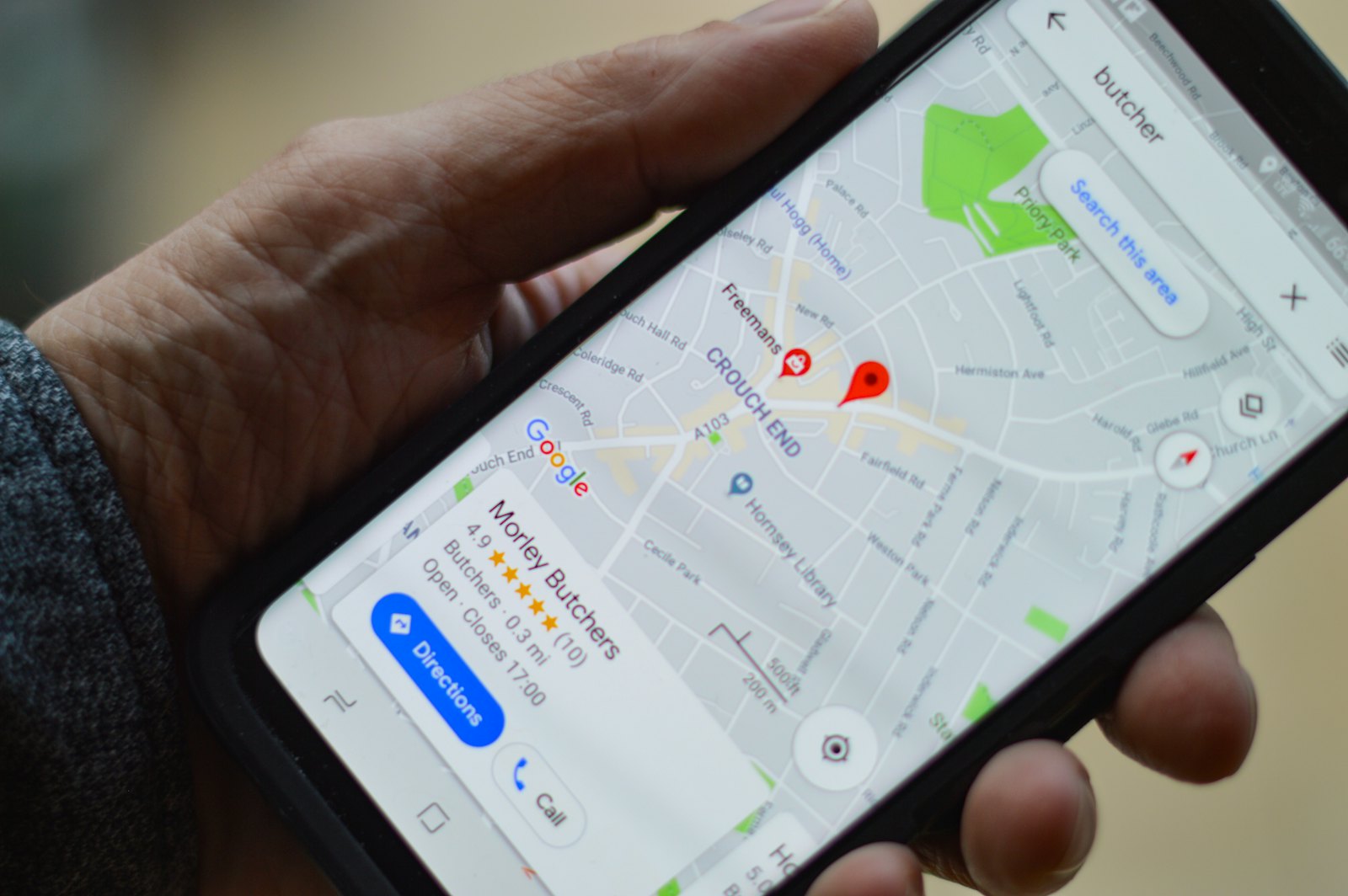 Hand met smartphone met een kaart en zoekresultaten van lokale bedrijven
